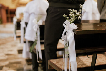 Flowers and Green Branches Decorating Church Pews for First Holy Communion
