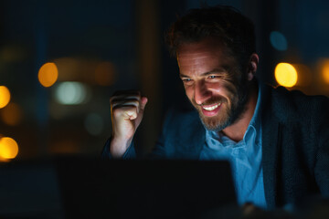 A man in a suit is looking at his laptop.