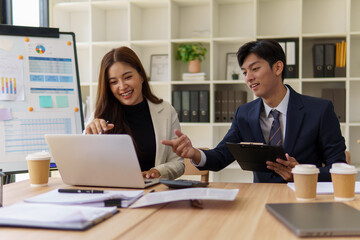 Young male and female colleagues collaborating on data and strategy during a meeting at a shared desk.
