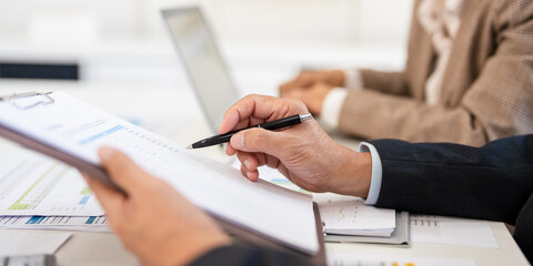 Man and woman are working on a presentation in meetimg room modern office. hand holding a clipboard...