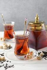 Tasty Turkish tea, sugar and pistachios on white wooden table