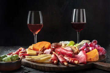 Antipasti or tapas. Charcuterie and cheese board with wine and olives, side view. Mediterranean gourmet food and drinks, delicatessen