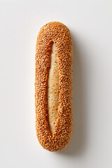 Fototapeta premium Italian loaf coated with sesame seeds sits on clean white surface highlighting its texture and detail. This minimalist presentation enhances culinary appeal