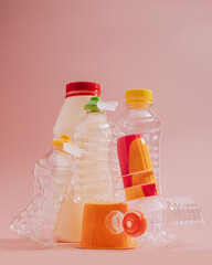 Conceptual balancing still life with plastic bottles on pink, retro, nostalgic style. Theme of...