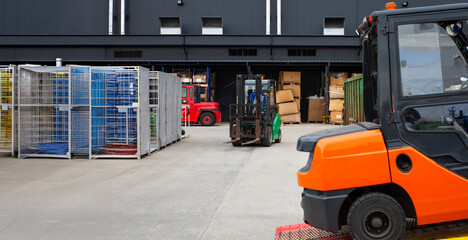 A forklift is parked in front of a building with a lot of boxes