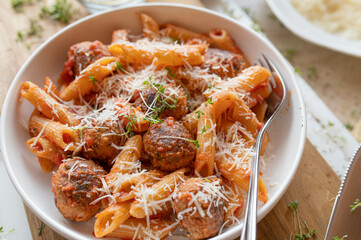 Tuna balls in a delicious tomato sauce with pasta and parmesan cheese on a plate