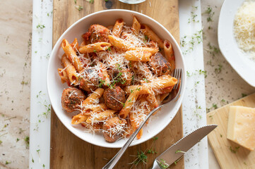 Tuna balls in a delicious tomato sauce with pasta and parmesan cheese on a plate