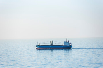 Cargo ship, bulk carrier sailing through the calm, blue sea.
