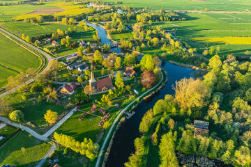 
Beautiful view from a drone of the village of Żelichowo in Żuławy, where the "Mały Holender" inn is located. Spring, evening. The Tuga River.