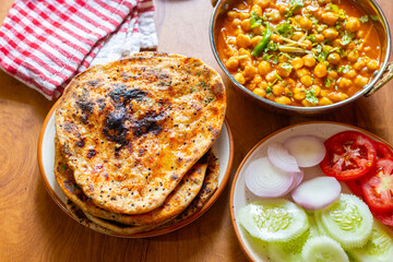 Amritsari kulcha is a stuffed Indian flatbread, crisp outside, soft inside, filled with spiced potatoes, baked in a tandoor, and served with chutney.
