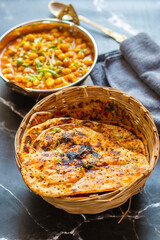 Amritsari kulcha is a crispy, flaky stuffed flatbread from Punjab, filled with spiced mashed potatoes or paneer, baked in a tandoor, and served hot with kabuli chana masala and salad
