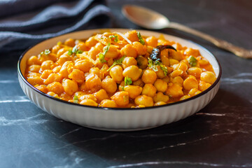 Kabuli Chana Masala is a flavorful North Indian curry made with chickpeas, tomatoes, onions, and aromatic spices, simmered to a rich, hearty consistency.
