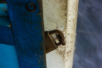Close-up of a rusty padlock on a blue painted surface. Represents security, age, and texture.

