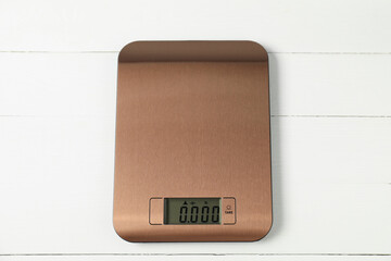 Modern electronic kitchen scale on white wooden table, top view