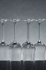 Many clean glass on mirror surface against light background