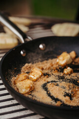 Melting brown sugar and butter in pan for dessert.