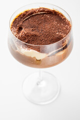 A glass of creamy tiramisu dessert with cocoa powder topping, showcasing rich layers and smooth texture. An appetizing treat perfect for culinary photography and gourmet presentations.