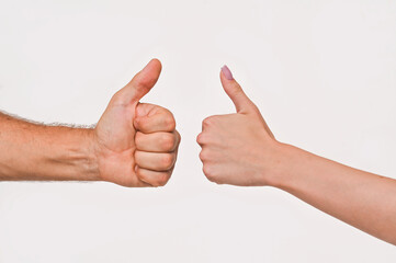 A man's and a woman's hand shows a class gesture. thumb up on a white background.