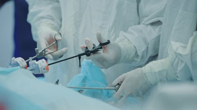 Surgeons performing laparoscopic surgery in operating room with precision instruments.