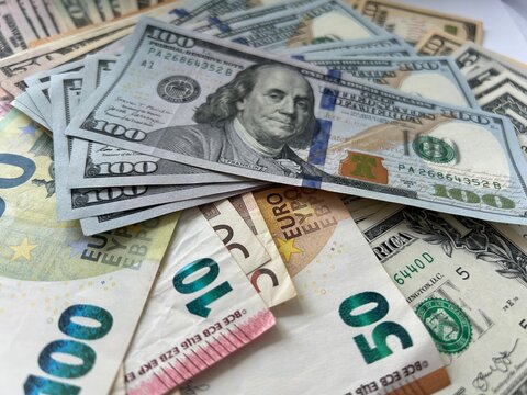 Close-up shot of Euro and US Dollar banknotes scattered on a flat surface, symbolizing global finance and currency exchange.