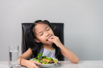 Little asian cute girl to eat healthy vegetables.Nutrition and healthy eating habits for kids concept.Children happy and like to eat vegetables.