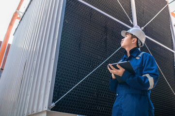 Young engineer working at large factory,Technician in protective uniform and with hardhat  checking temperature in pipes