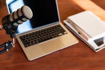 Podcast recording setup featuring a microphone and laptop for educational interviews and training sessions