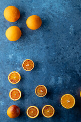 Fresh oranges and blood oranges on textured surface