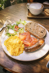 Sunlit Gourmet Breakfast -Fluffy Omelette with Smoked Salmon, Savory Sausage and Fresh Radish-Tomato Salad, Whole Grain Toast and Artisan Coffee.