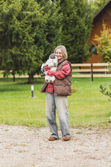 Fototapeta premium beautiful girl walking with a dog, girl holding a pug in her arms