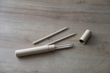 Naklejka premium Eco-friendly wooden pencils with cardboard pencil case on a wooden table