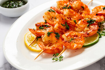 Fried shrimp, headless, on skewers, shrimp kebabs, with spices and herbs, grilled, homemade, without people,