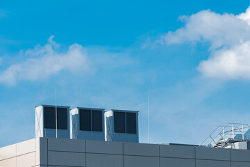 Rooftop cooling units under clear blue sky on sunny day