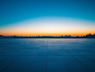 Empty plaza at sunset, city skyline in background.