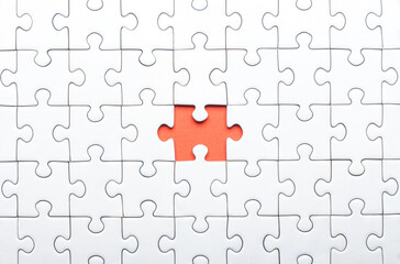 White Puzzle with Single Missing Piece Revealing orange Background