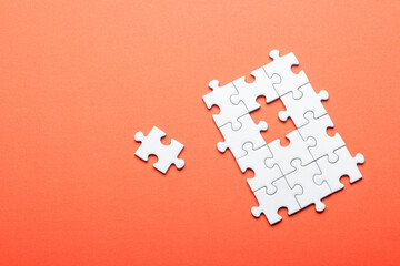 White puzzle with missing piece on bright orange background