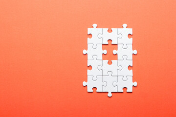 White Puzzle with Missing Piece on Orange Background