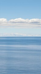 Calm ocean horizon under a bright sky with fluffy clouds; coastal serenity, perfect for travel brochures