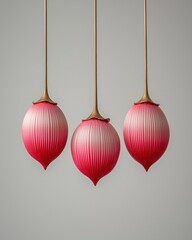 Trio of pink objects hung with golden stems, simple background