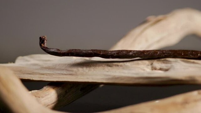 Gousse de vanille pos&eacute;e sur du bois, cadrage serr&eacute; et travelling lat&eacute;ral