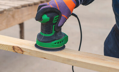 Man sanding wooden boards. Selective focus.