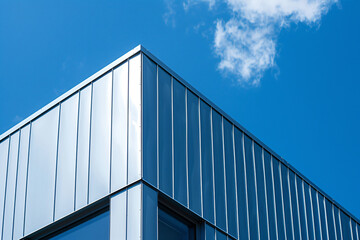 a building with a sky background and a plane flying overhead