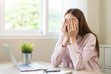 Stressed, exhausted asian young woman having migraine symptoms headache, bored sitting work long...