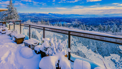 Scenic winter view across Fraser Valley, BC, Canada from snowbound penthouse patio with alpine mountains on horizon.