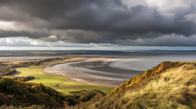 Stunning coastal view of a sandy beach and rolling hills under dramatic stormy clouds