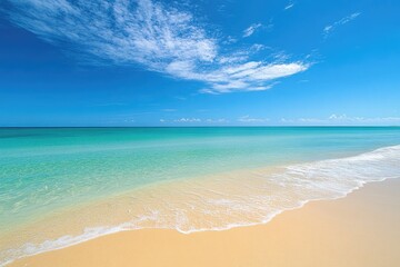 Fototapeta premium Ocean Meets Golden Sand Under Blue Sky with Wispy Clouds, Horizon in Background