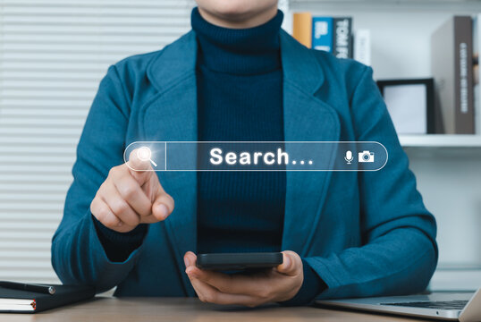 SEO, Search Engine Optimization and Web Search Interface Concept. Woman pointing at search bar and holding smartphone, representing online search, SEO, web visibility strategies, and digital browsing.