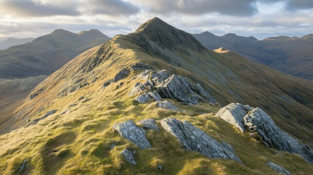 Majestic mountainous landscape with rocky terrain and grassy vegetation under sunlight