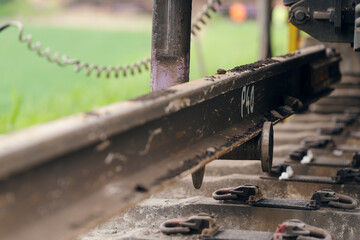A worker in the process of arailroad track weld repair with a freight train passing