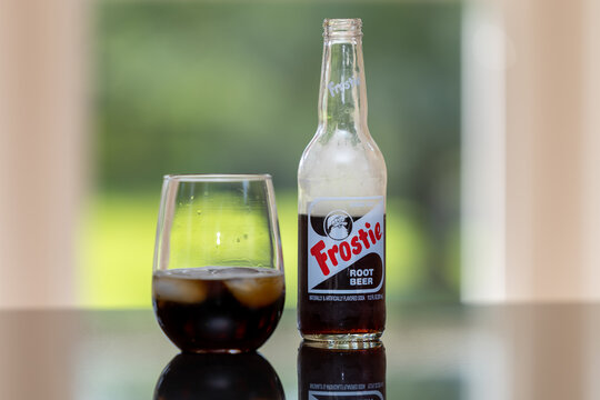 Frostie Root Beer soda bottle isolated with glass and ice